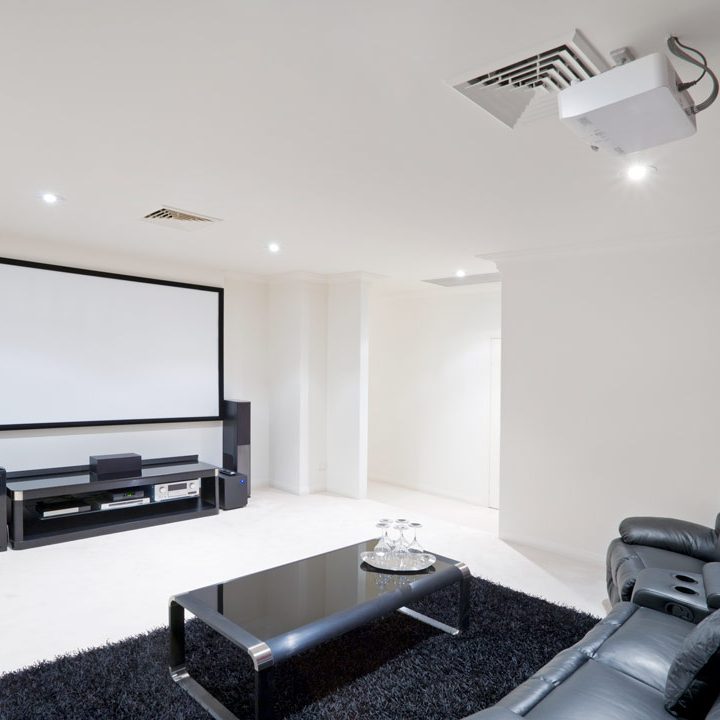an entertainment room with black couches